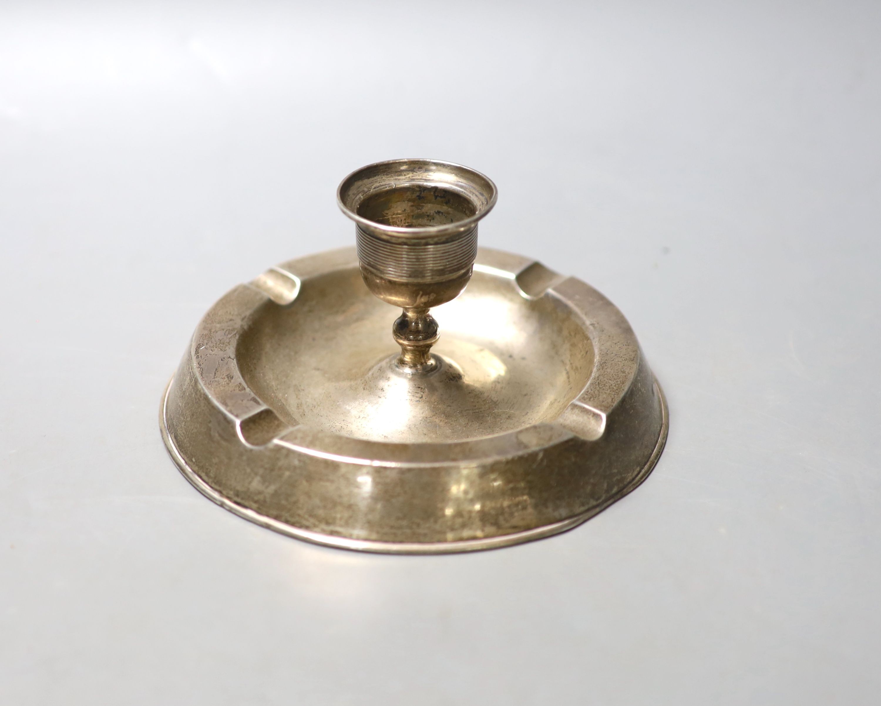 An Edwardian silver mounted combination ashtray/candlestick, Birmingham, 1908, diameter 14.4cm, weighted.